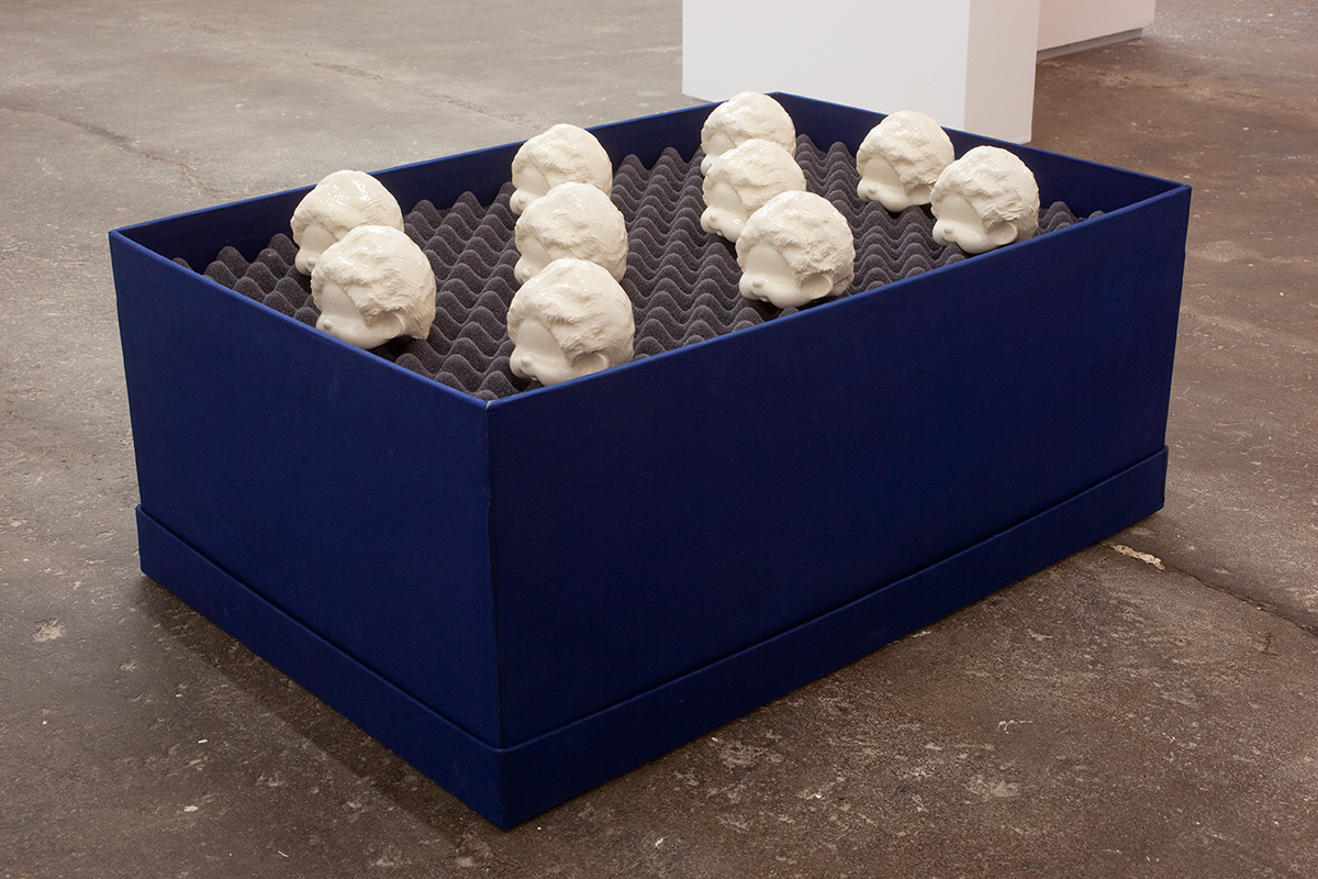 モンチッチ 頭部, 2012. Ten glazed, porcelain slip casts, foam, buckram covered box. 21 x 17 x 21 inches.